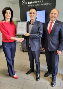 Kobieta z dwoma mężczyznami trzymają certyfikat współpracy
