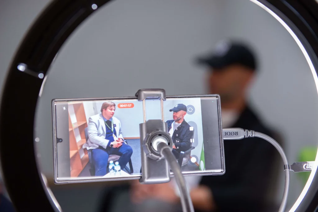 Ekran telefonu nagrywający mężczyznę za lampą