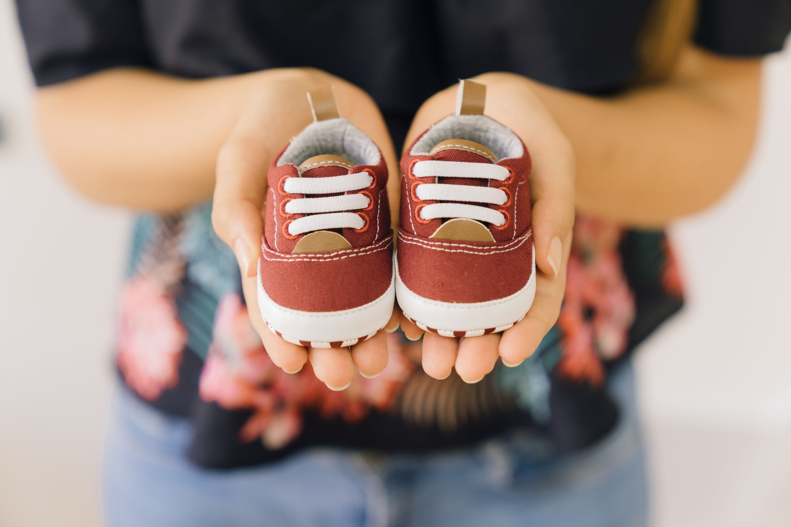 Dziecięce buty trzymane w dłoniach